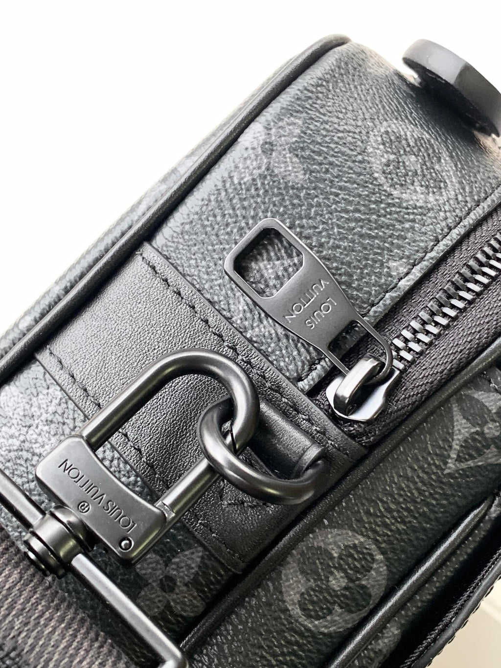 Men’s Louis Vuitton bag close-up of zipper pull and logo patch