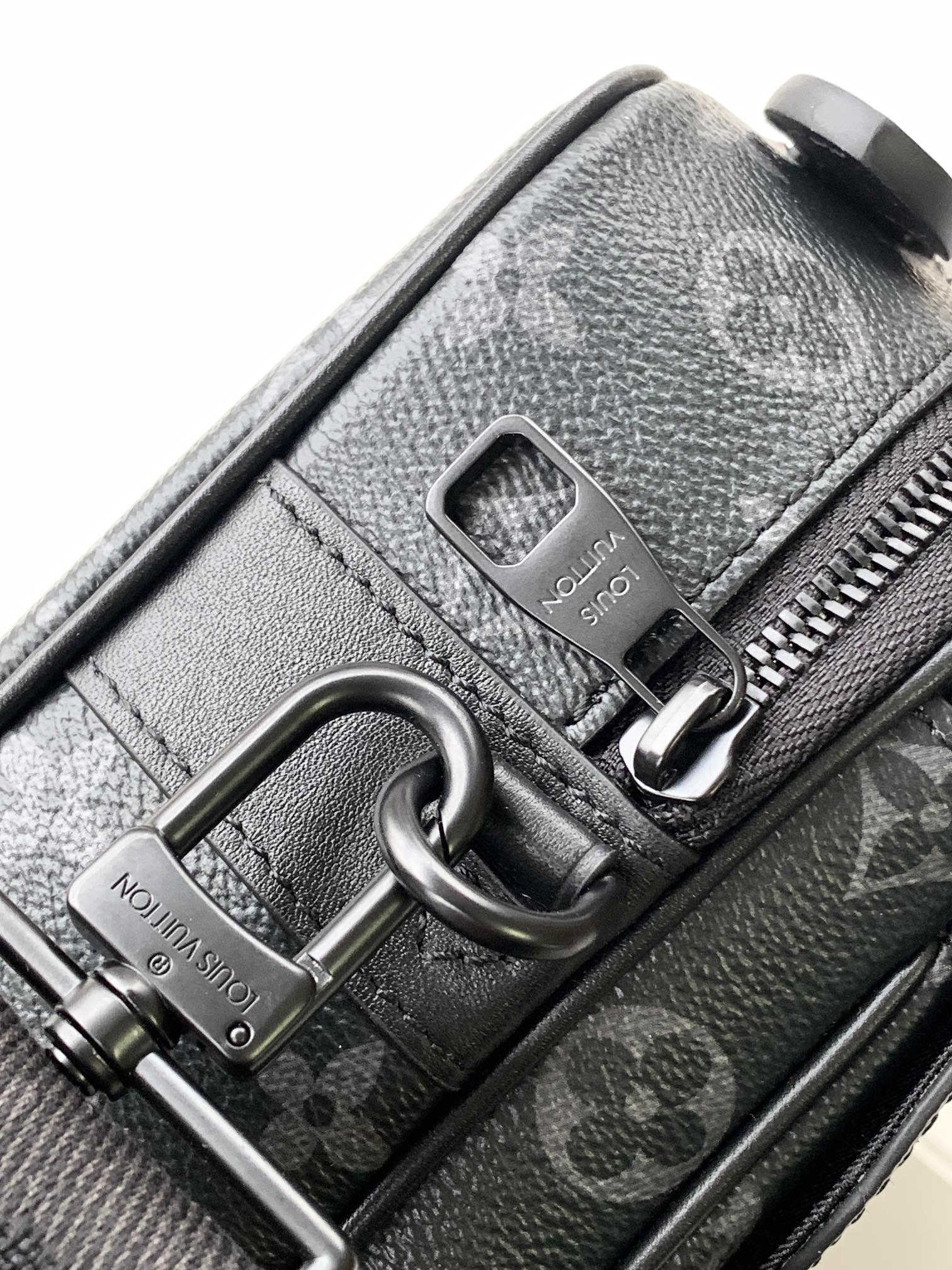 Men’s Louis Vuitton bag close-up of zipper pull and logo patch