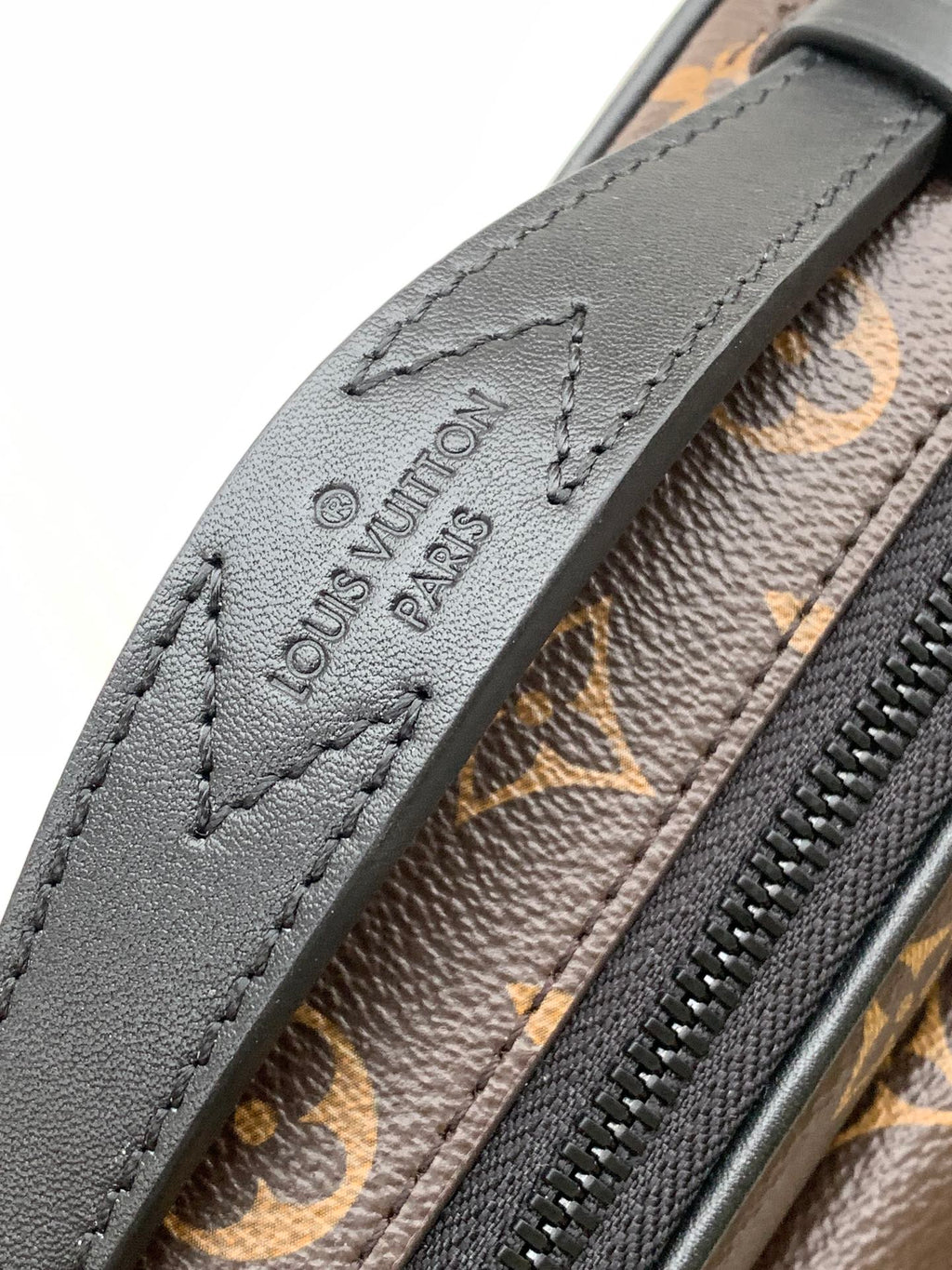 Men's Louis Vuitton monogram bag strap closeup with embossed Louis Vuitton Paris