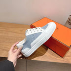 White and light-blue sneakers, back view with white heel tab and logo text.