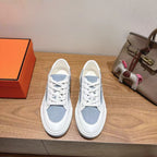 White and light-blue lace-up sneakers with low profile rubber sole.