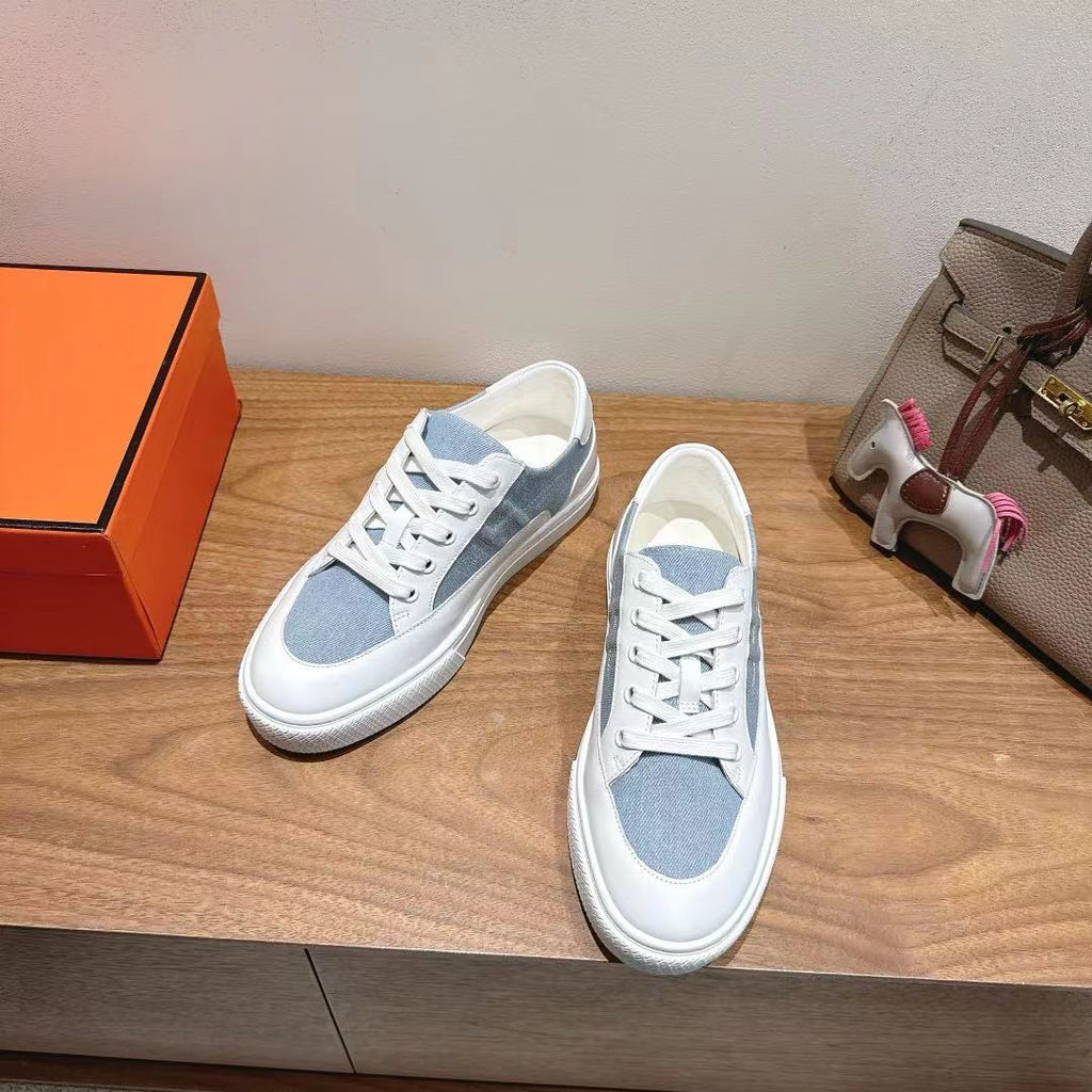 White and light-blue lace-up sneakers, side view with stitched panel details.