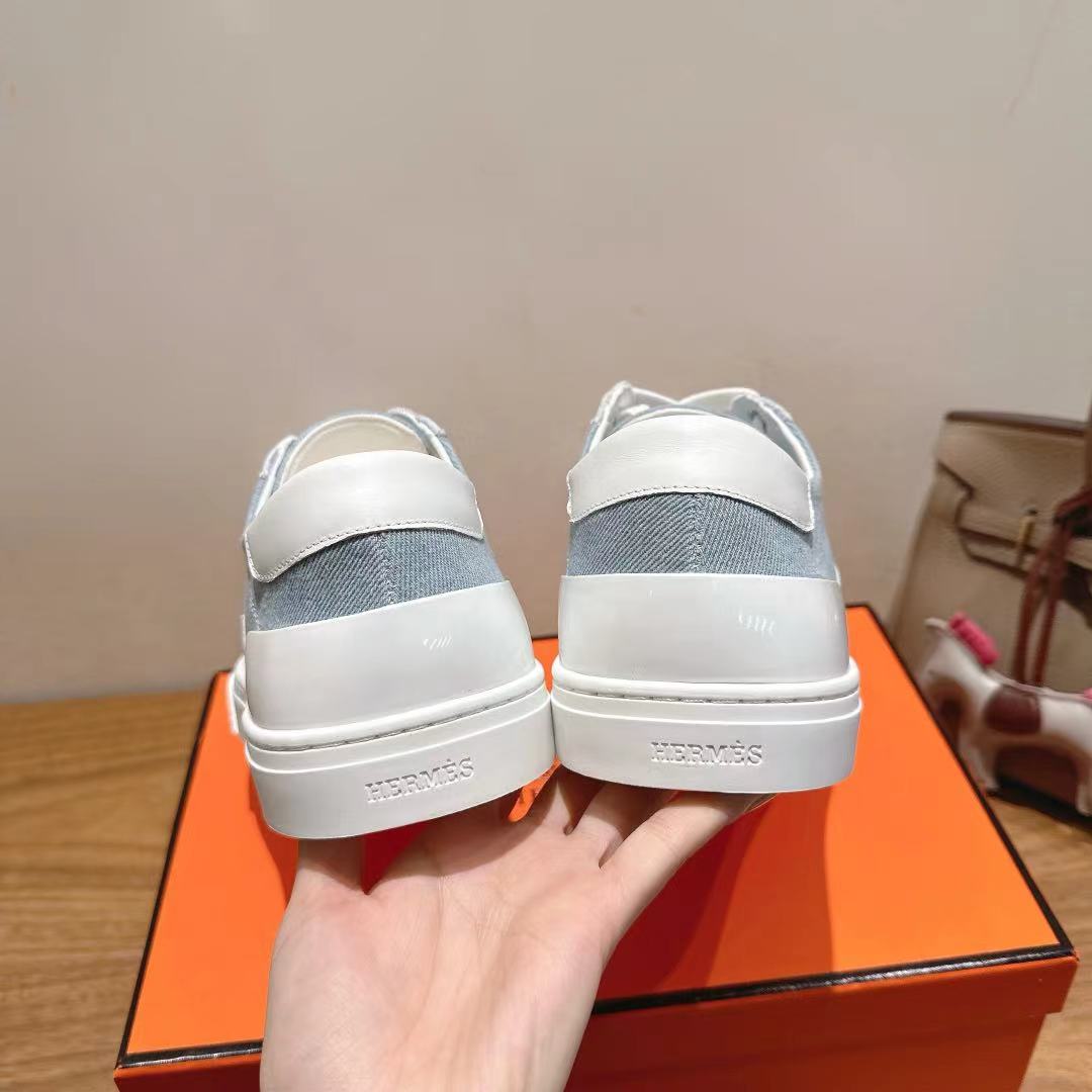 White and light-blue sneakers, close rear view showing cushioned collar and stitching.