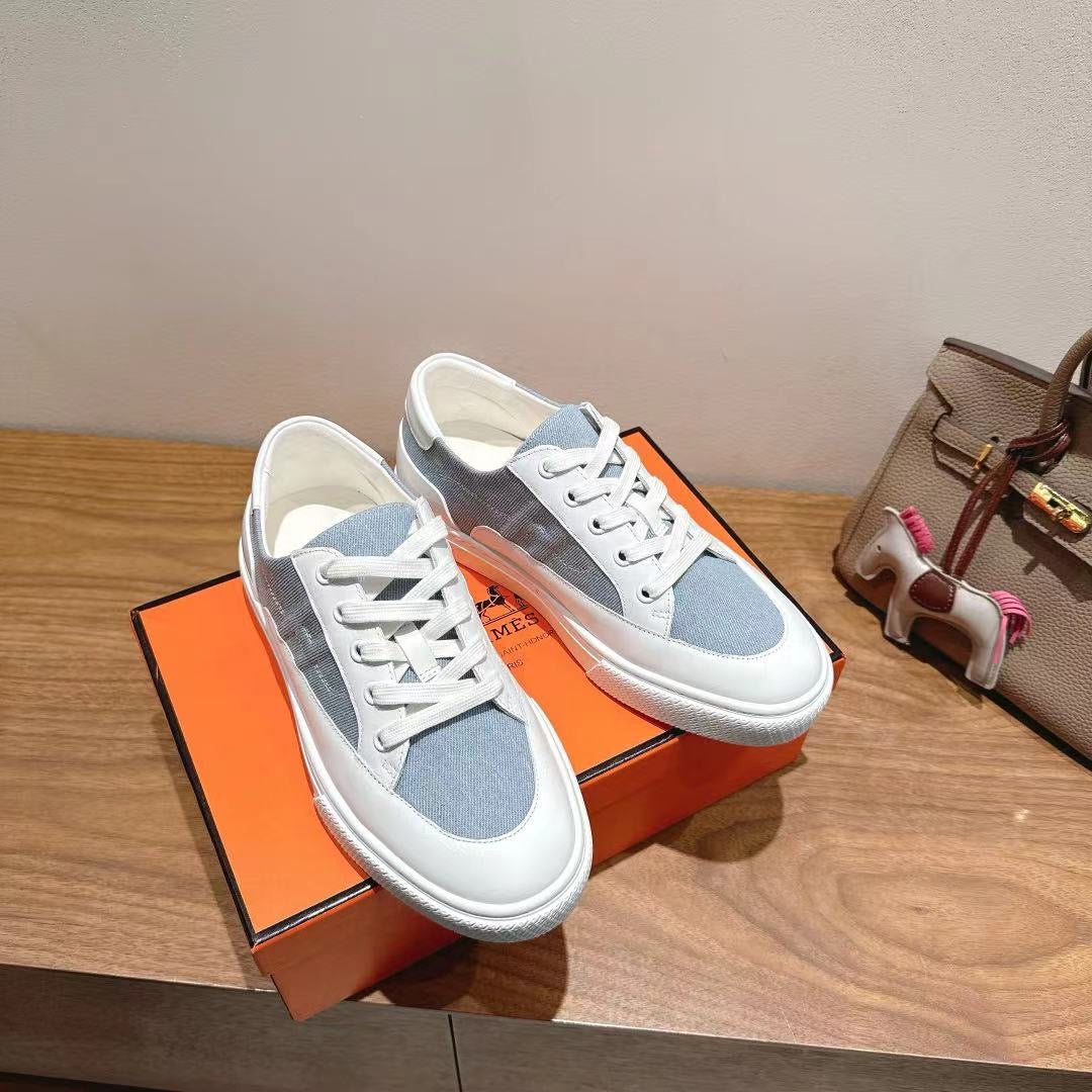 White and light-blue lace-up sneakers, front view with insole logo lettering.