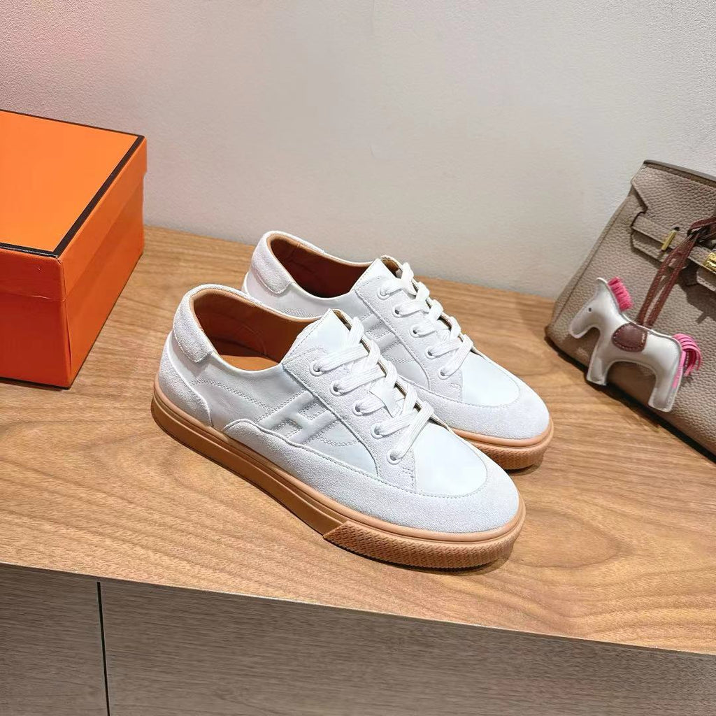 White leather lace-up sneakers with tan rubber sole, low profile
