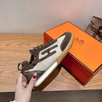 Held lace-up sneaker with dark gray and white mesh upper and tan gum sole.