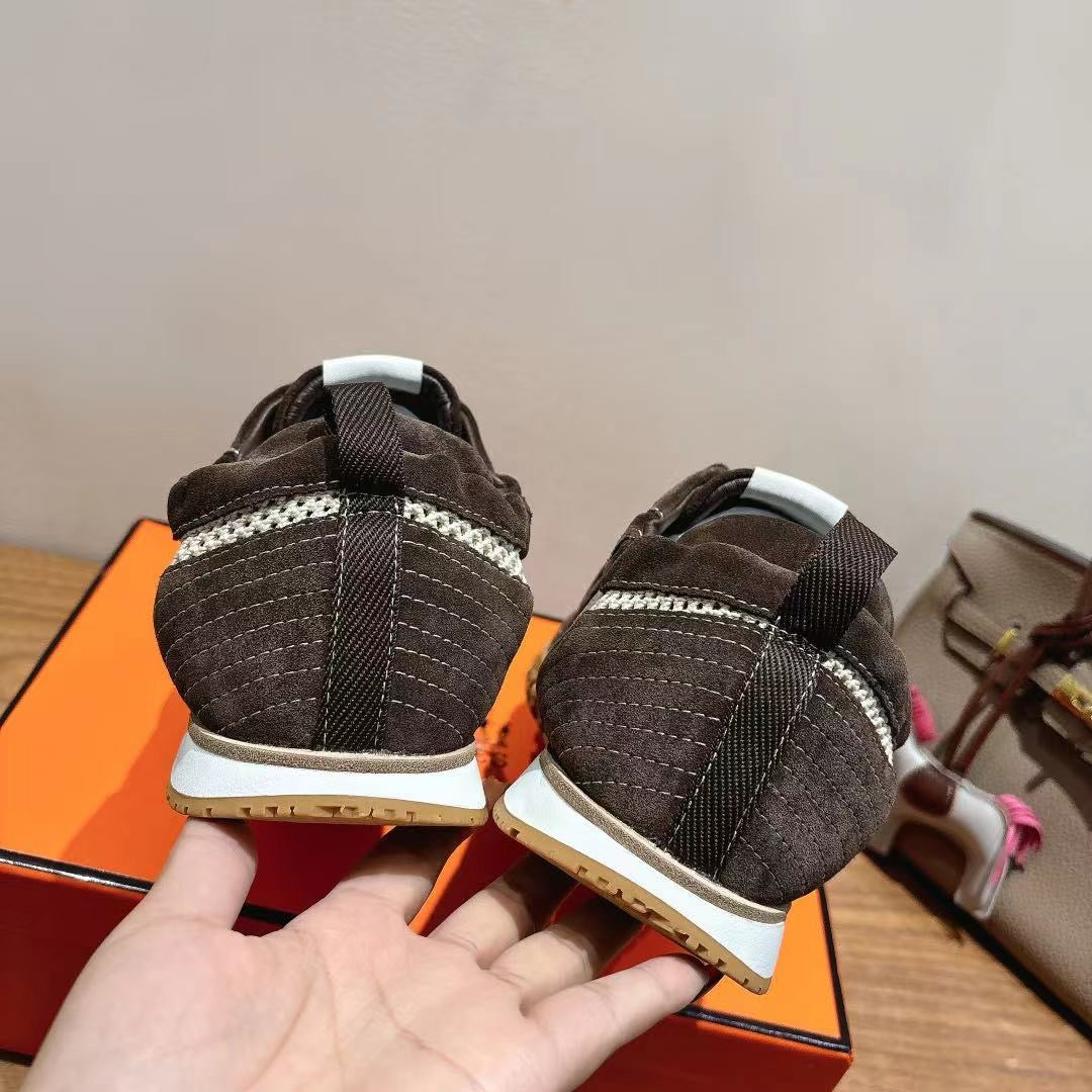 Heel view of dark gray lace-up sneakers with white midsoles and brown textured outsoles.