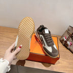 Single sneaker with patterned tan outsole, dark gray upper, and white side panels.