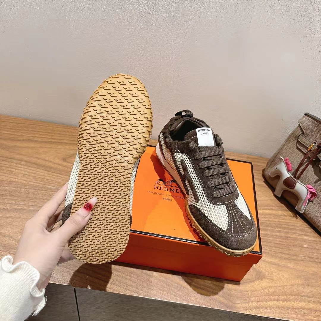 Single sneaker with patterned tan outsole, dark gray upper, and white side panels.