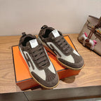 Pair of lace-up low-top sneakers in dark gray and white with gum rubber soles.