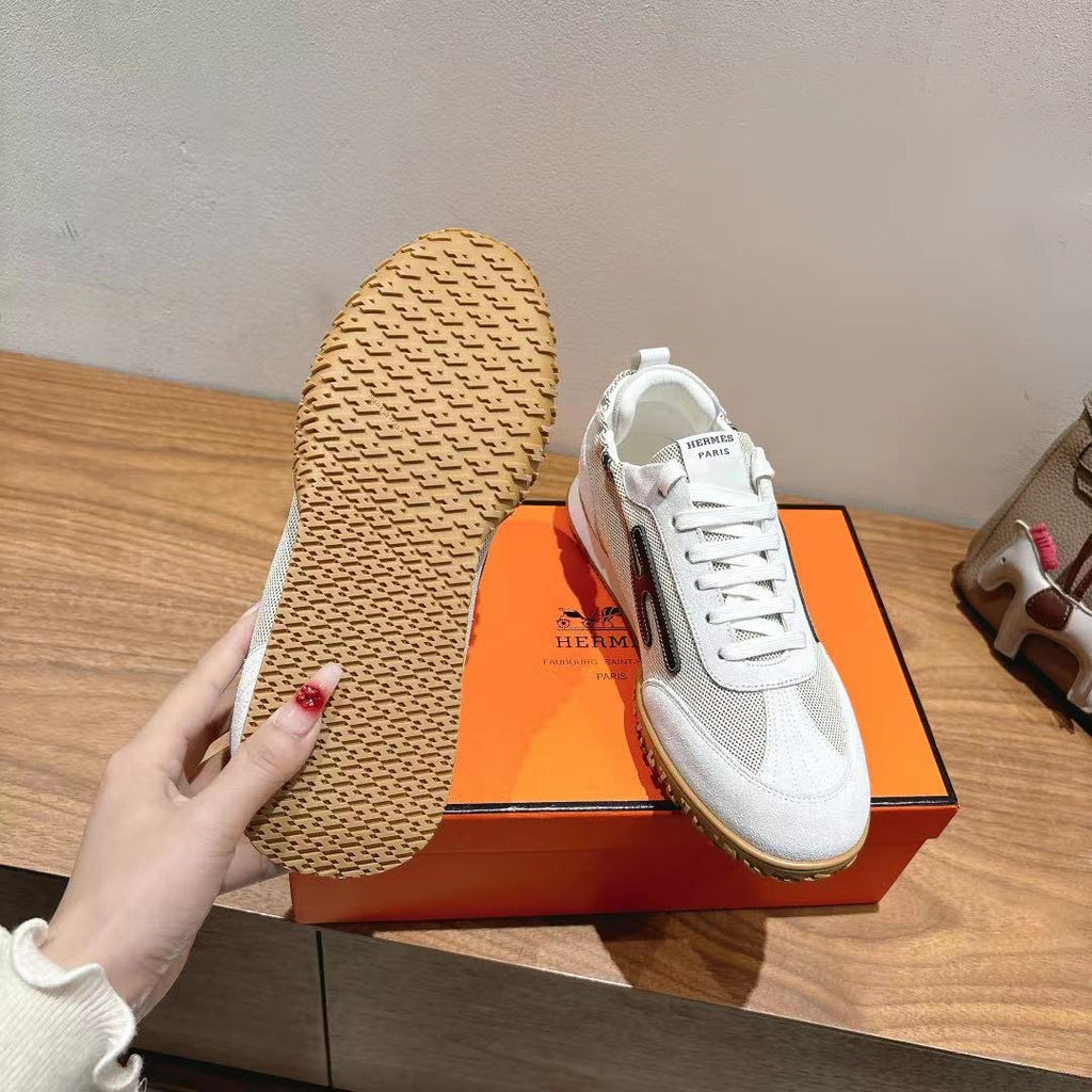 Hermes unisex white sneaker outsole view with textured tread and side stripe.