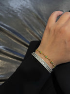 Gold chain bracelet with green star gemstones on a wrist