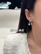 Hoop earrings with dangling charms, silver-tone, side view on ear