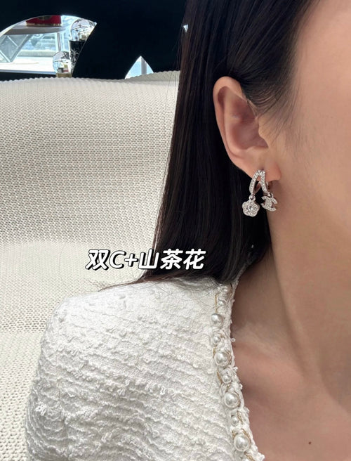 Hoop earrings with dangling charms, silver-tone, side view on ear