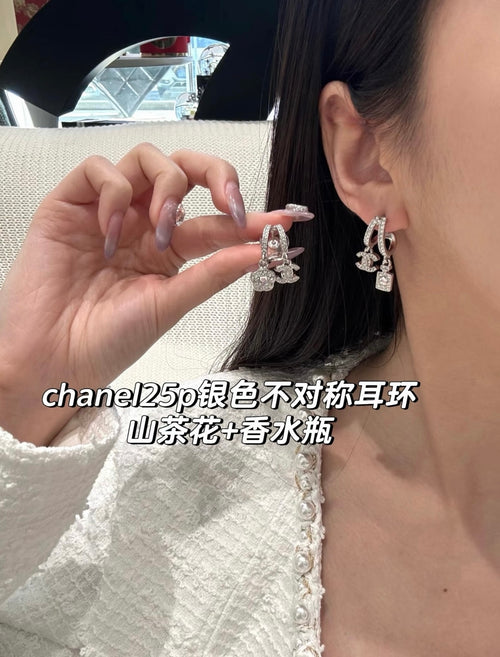Chanel hoop earrings with dangling charms, silver-tone, close-up on ear