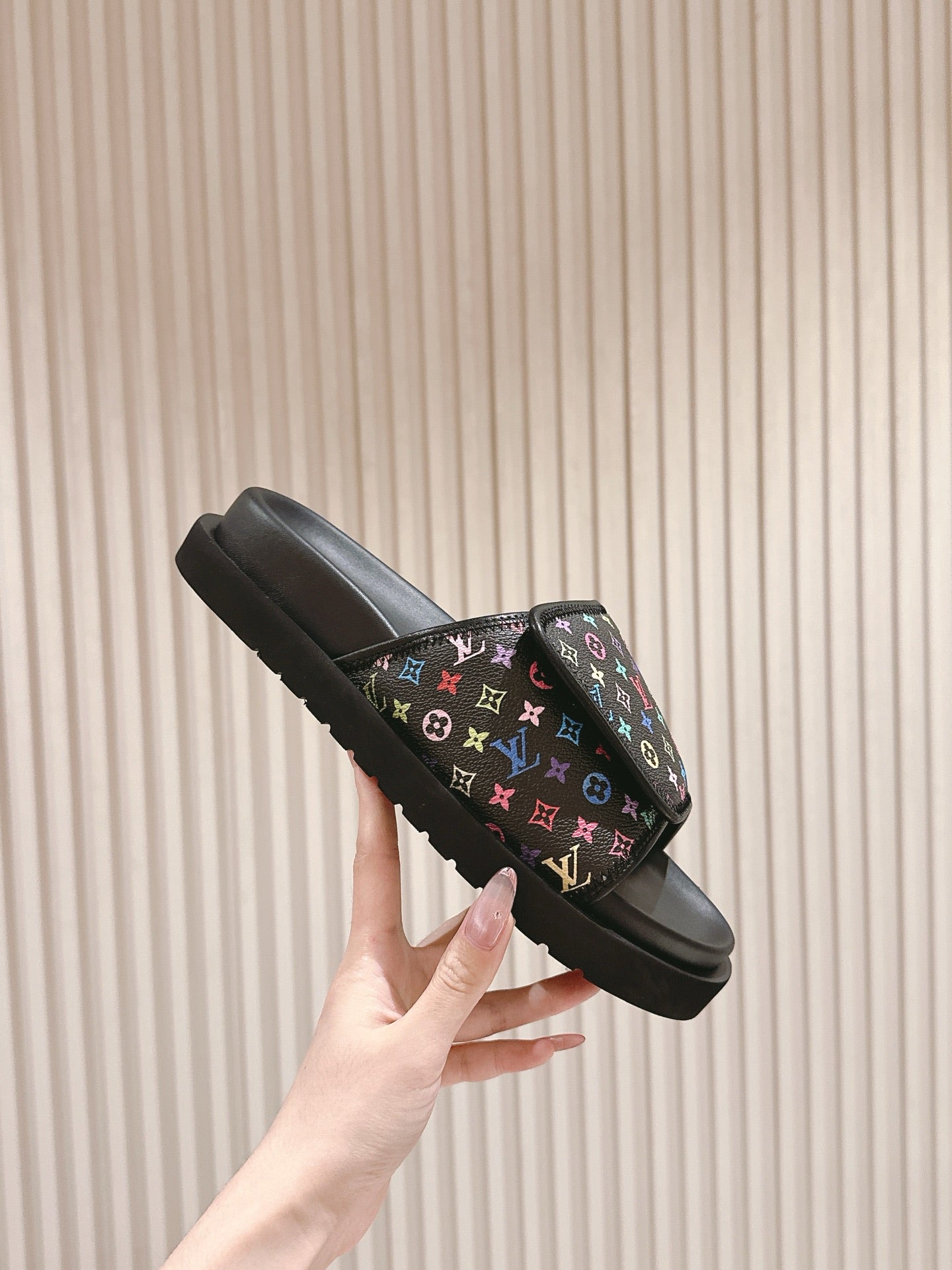 Louis Vuitton slide sandals, side view with black sole and multicolor monogram upper