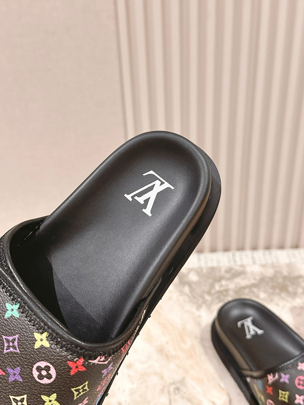 Louis Vuitton slide sandal top view, black molded strap with white logo mark