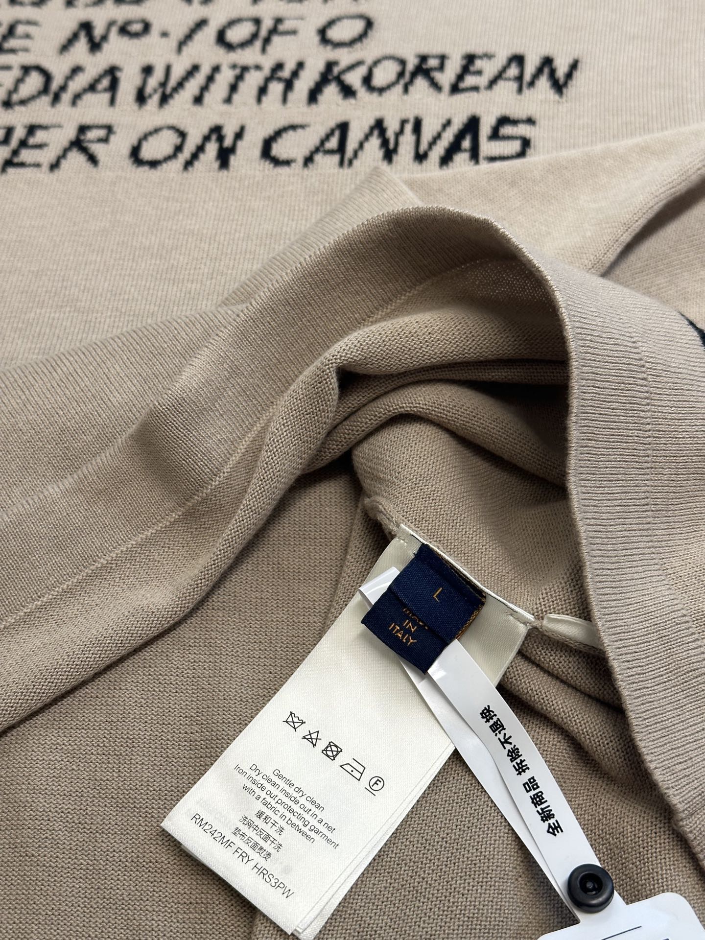 Light beige T-shirt fabric fold with white care tag and blue brand hangtag