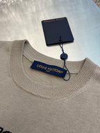 Light beige knit crewneck T-shirt with brand neck label and attached hangtag