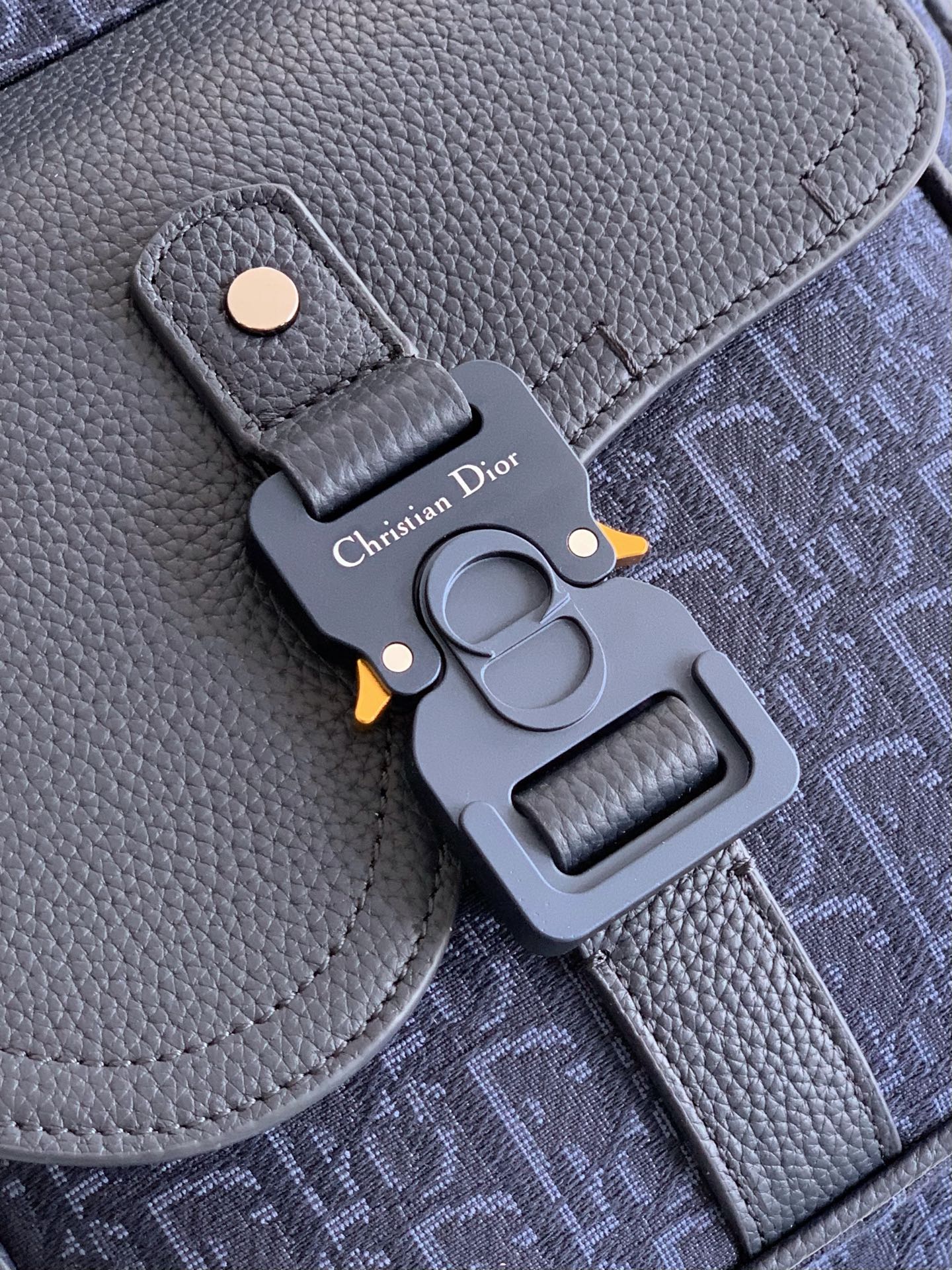 Blue leather Dior keychain charm with logo on a gray buckle strap
