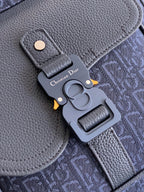 Dior bag close-up of gray leather tab, blue monogram fabric, and metal key charm