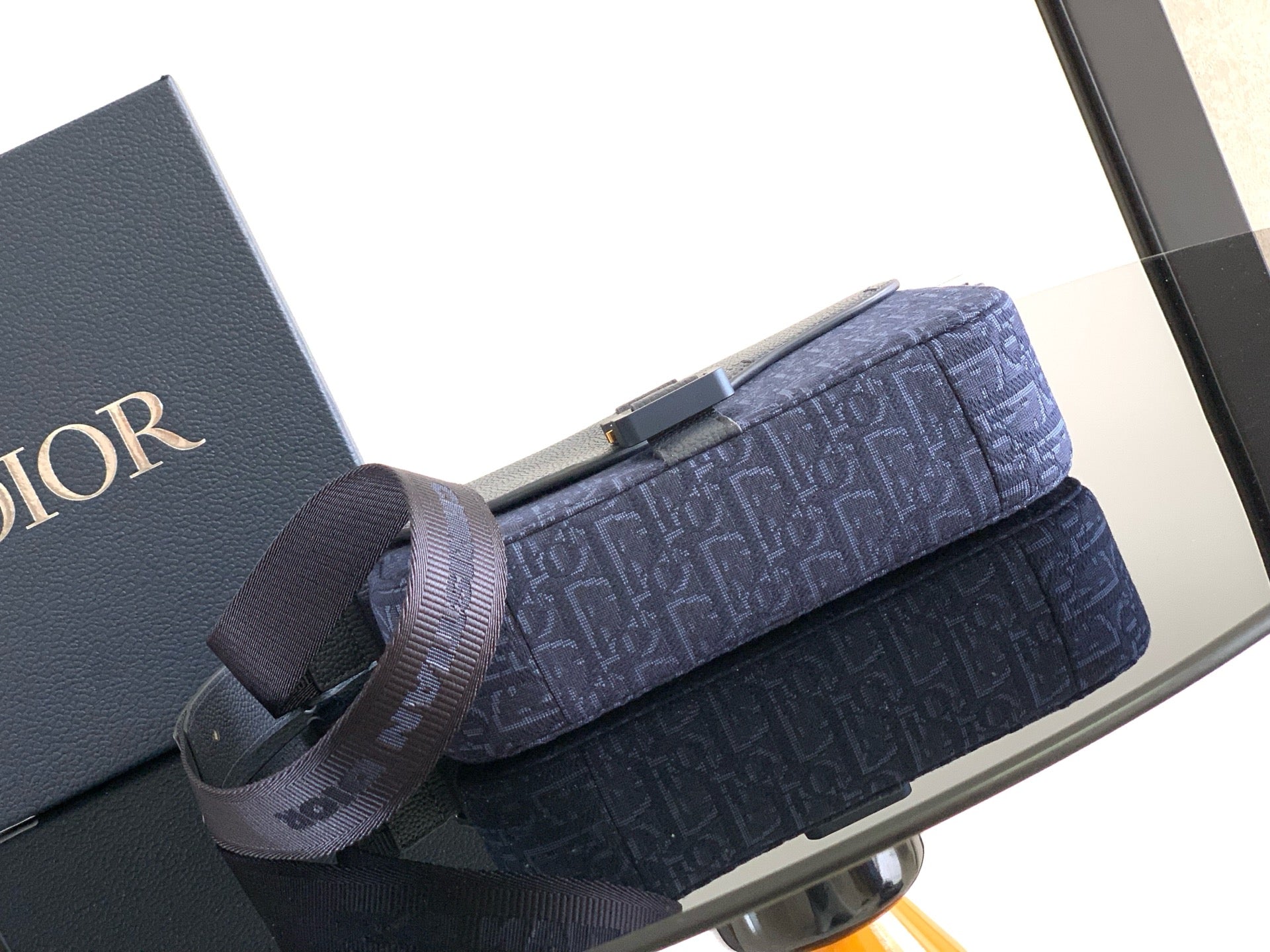 Dior bag with shoulder strap and flap, navy blue logo canvas on display