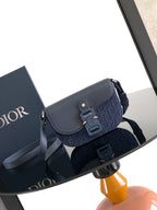 Navy Dior crossbody bag with flap and adjustable strap, gold-tone hardware.