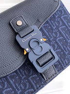 Navy Dior bag close-up showing D-logo charm and flap hardware on textured fabric.