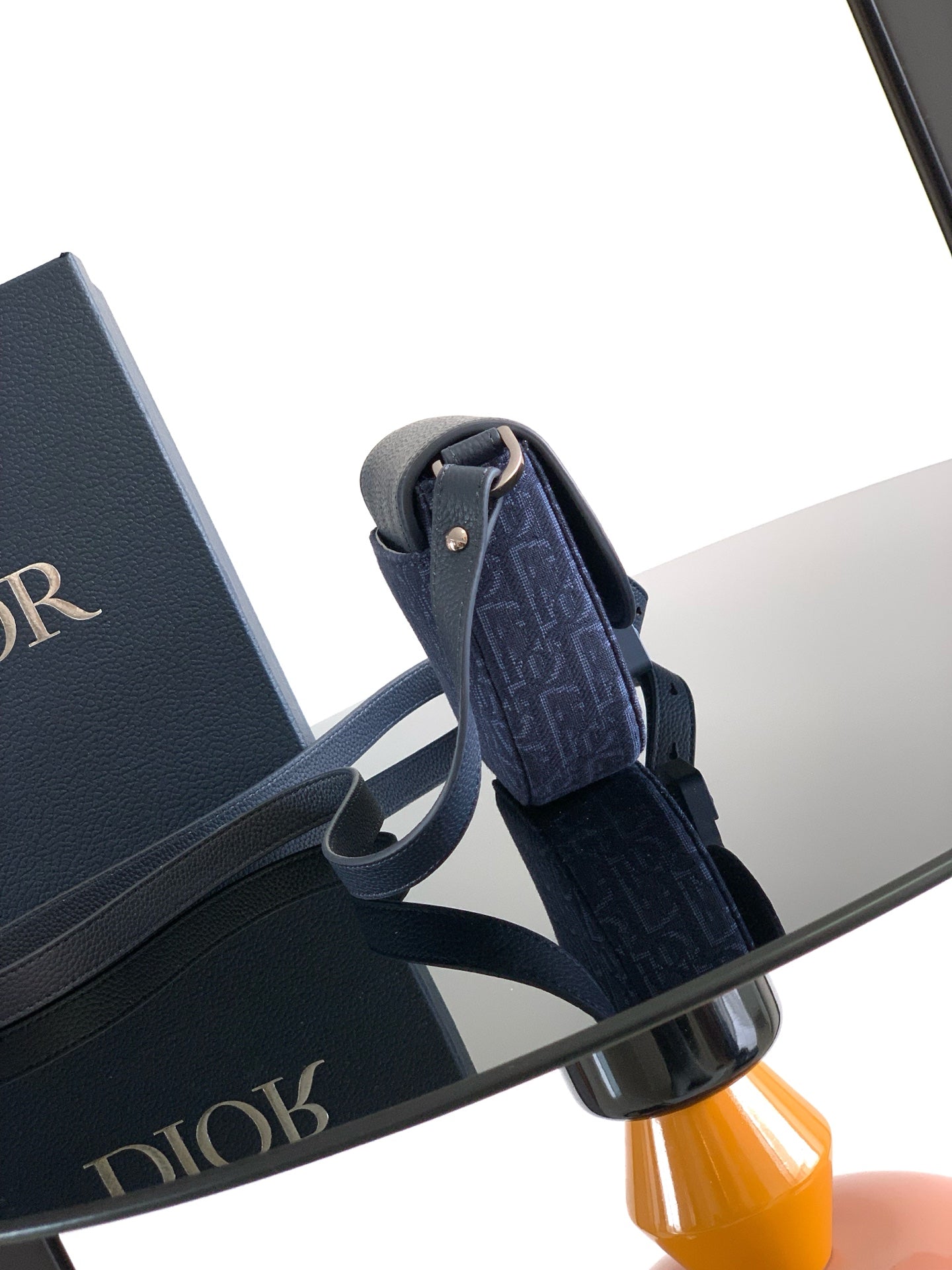 Navy Dior shoulder bag with flap and patterned fabric exterior, adjustable strap.