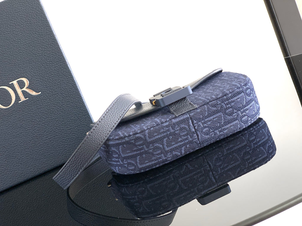 Navy Dior mini crossbody bag with textured logo fabric and top handle strap.