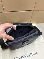 Dark monogram crossbody bag open, showing inner compartment and zip pocket