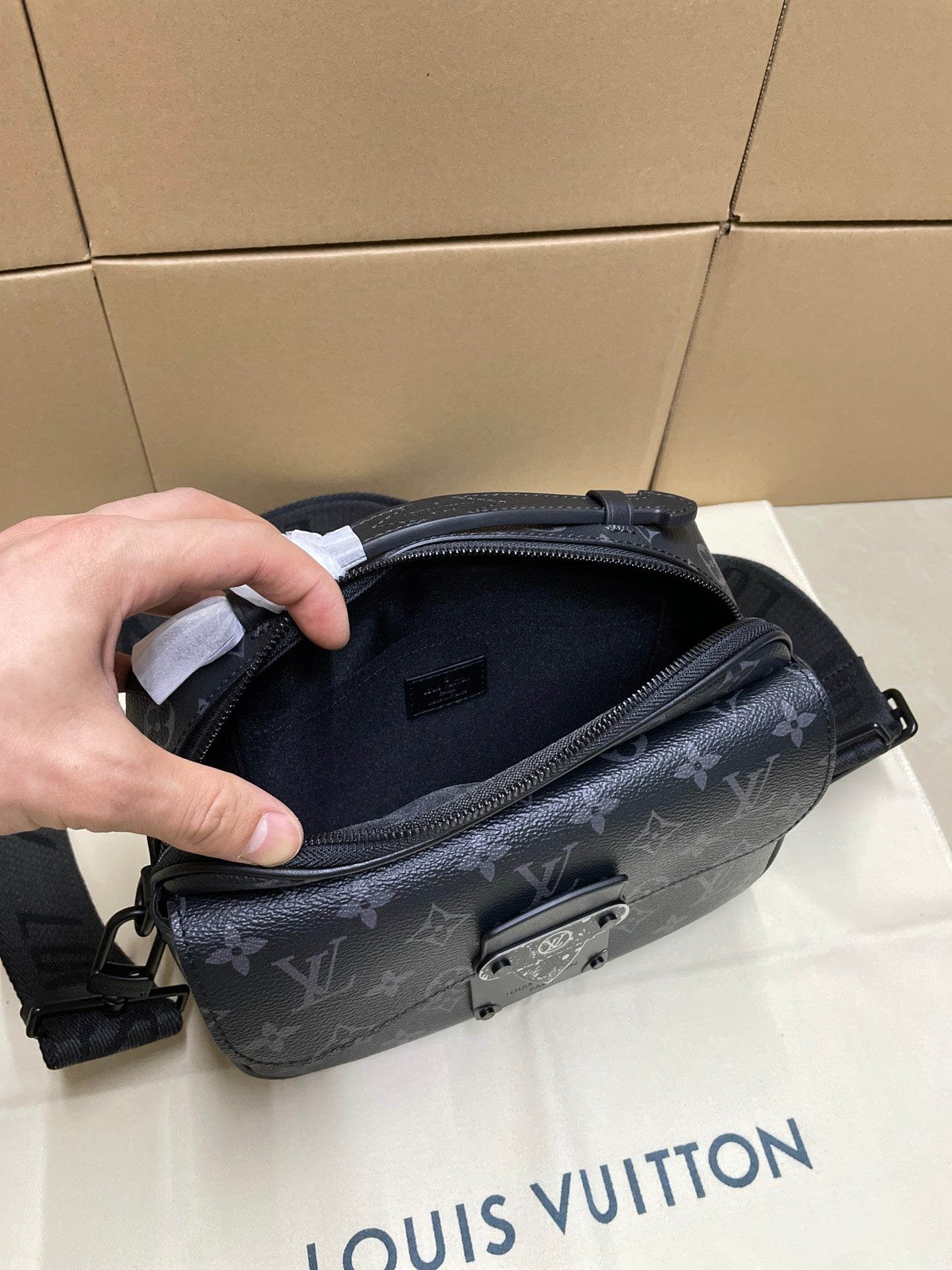 Dark monogram crossbody bag open, showing inner compartment and zip pocket