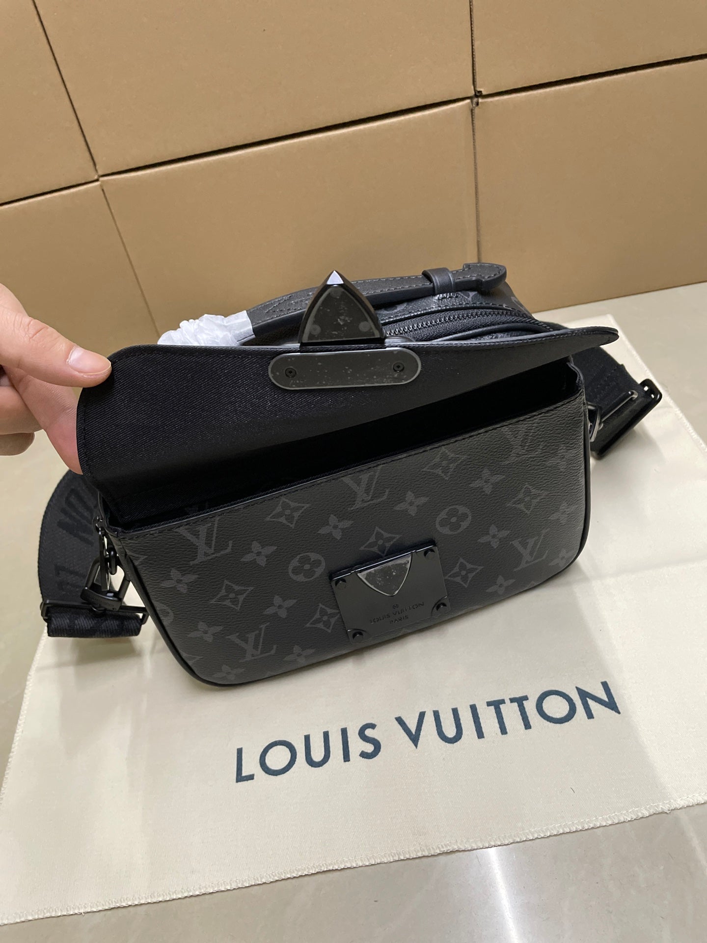 Men’s Louis Vuitton monogram crossbody bag held open for view of interior