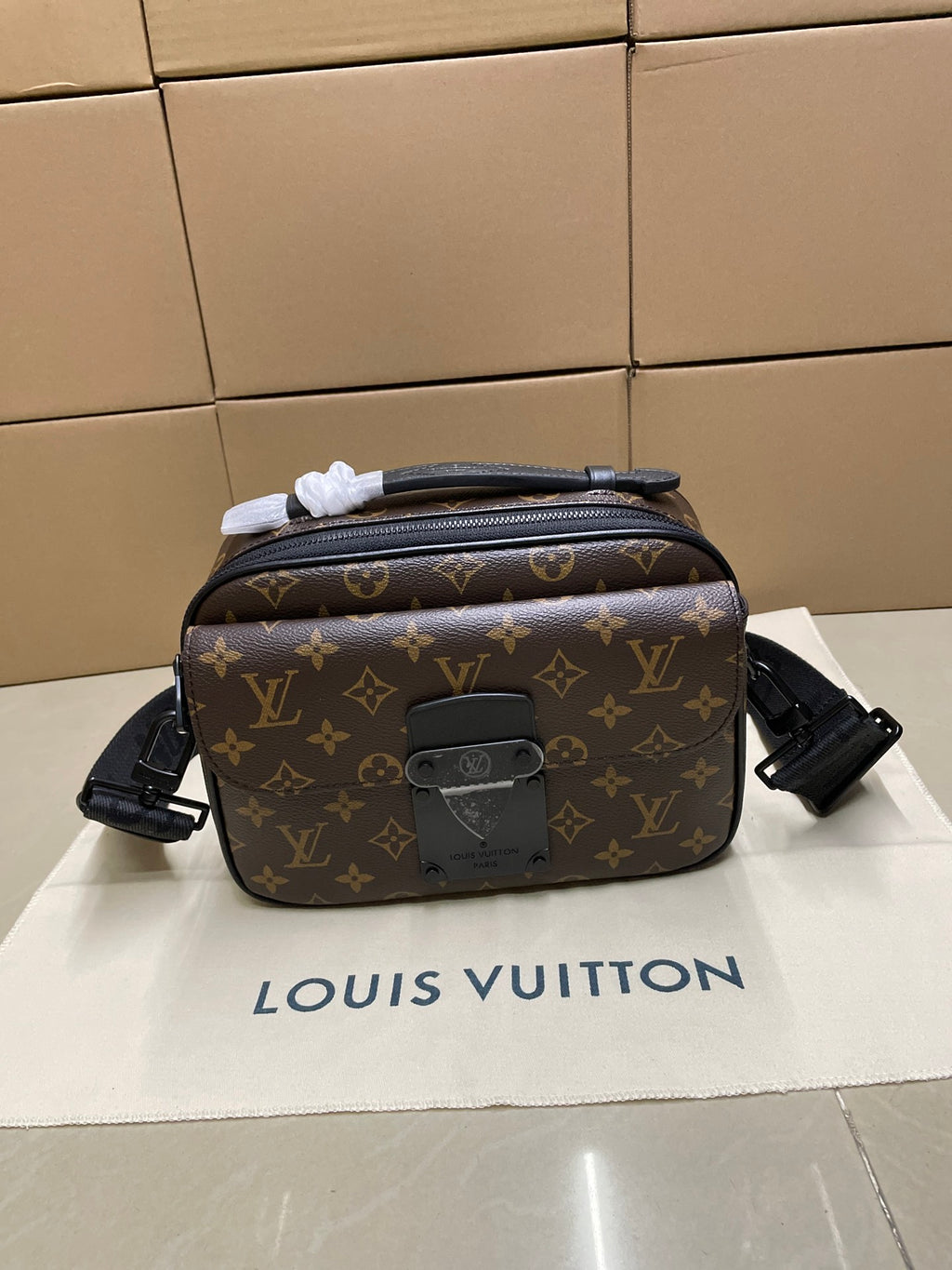 Louis Vuitton monogram crossbody bag with black leather trim and front zip pocket