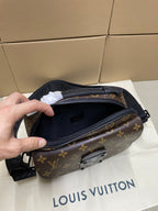 Louis Vuitton monogram crossbody bag held open, showing interior lining and zipper