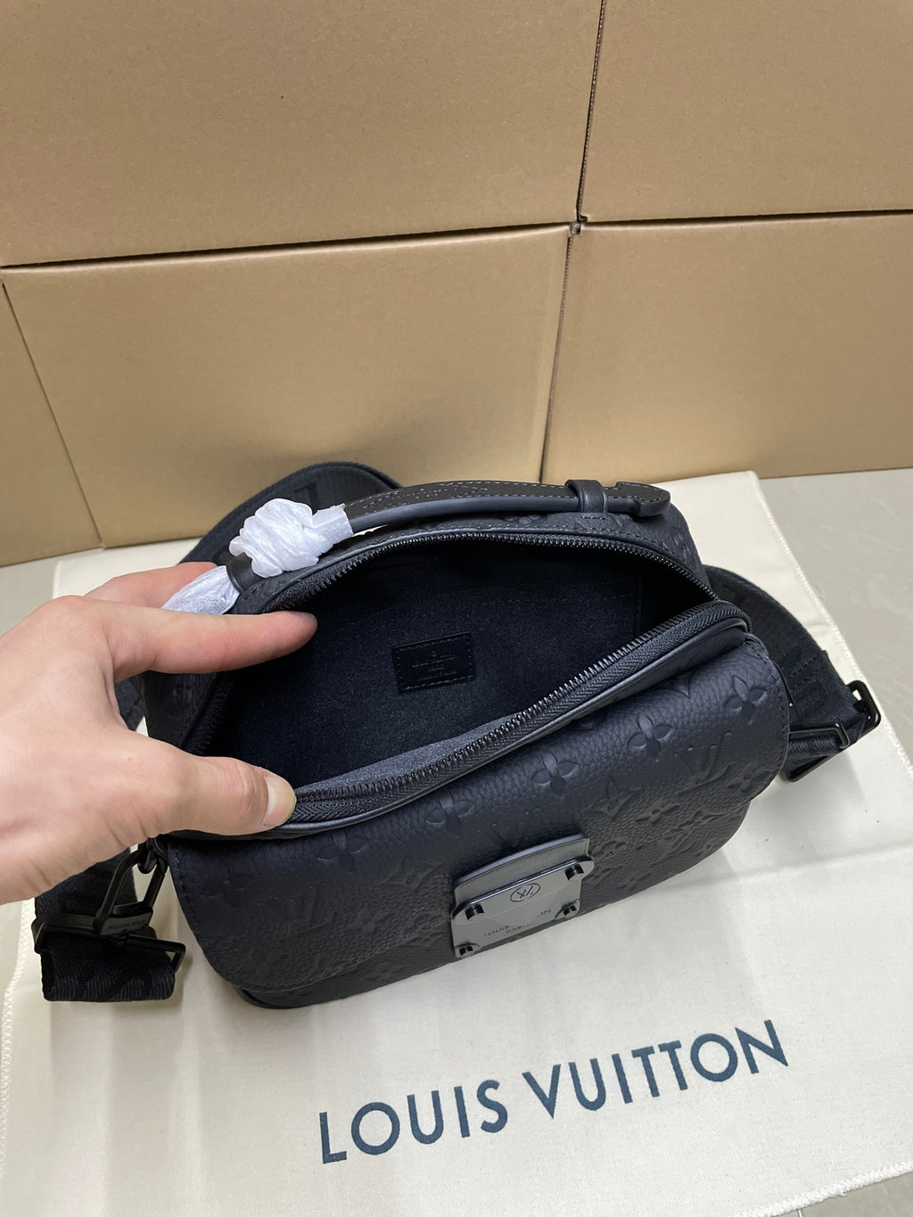 Louis Vuitton men's crossbody bag side view with zip pocket and dark monogram texture