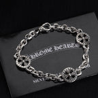 Silver-tone charm bracelet with round wheel charms and chain links