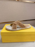 Fendi slide sandals with tan F-pattern straps and braided jute-textured footbed.