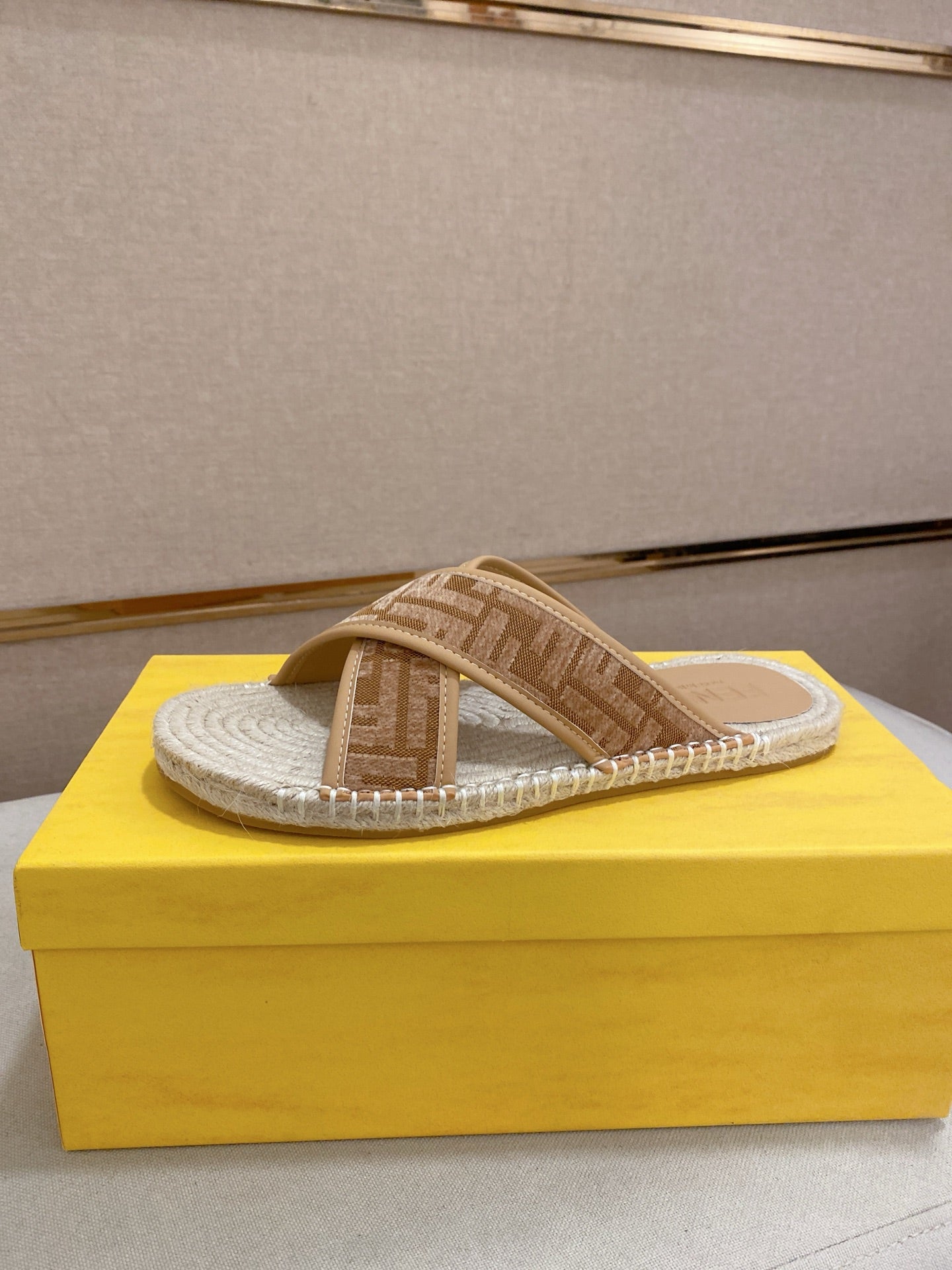 Fendi slide sandals with tan F-pattern straps and braided jute-textured footbed.