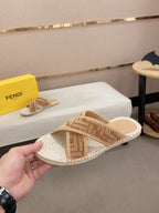 Fendi slide sandals with tan monogram-style straps and braided jute-textured sole.