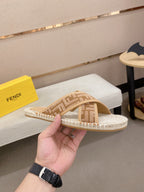 Fendi slide sandals with tan woven F-pattern straps and low open-toe heel.