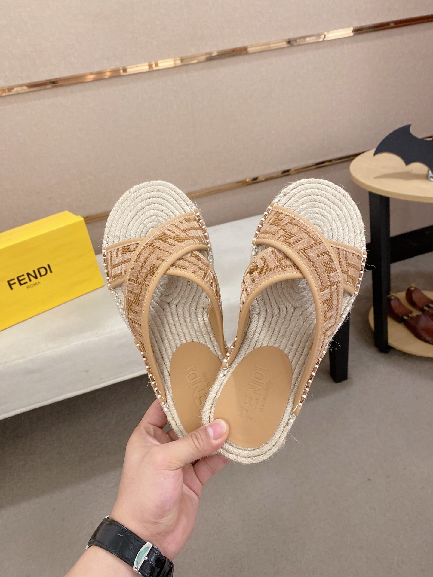 Fendi slip-on sandals with tan F-pattern straps and braided jute-textured footbeds.