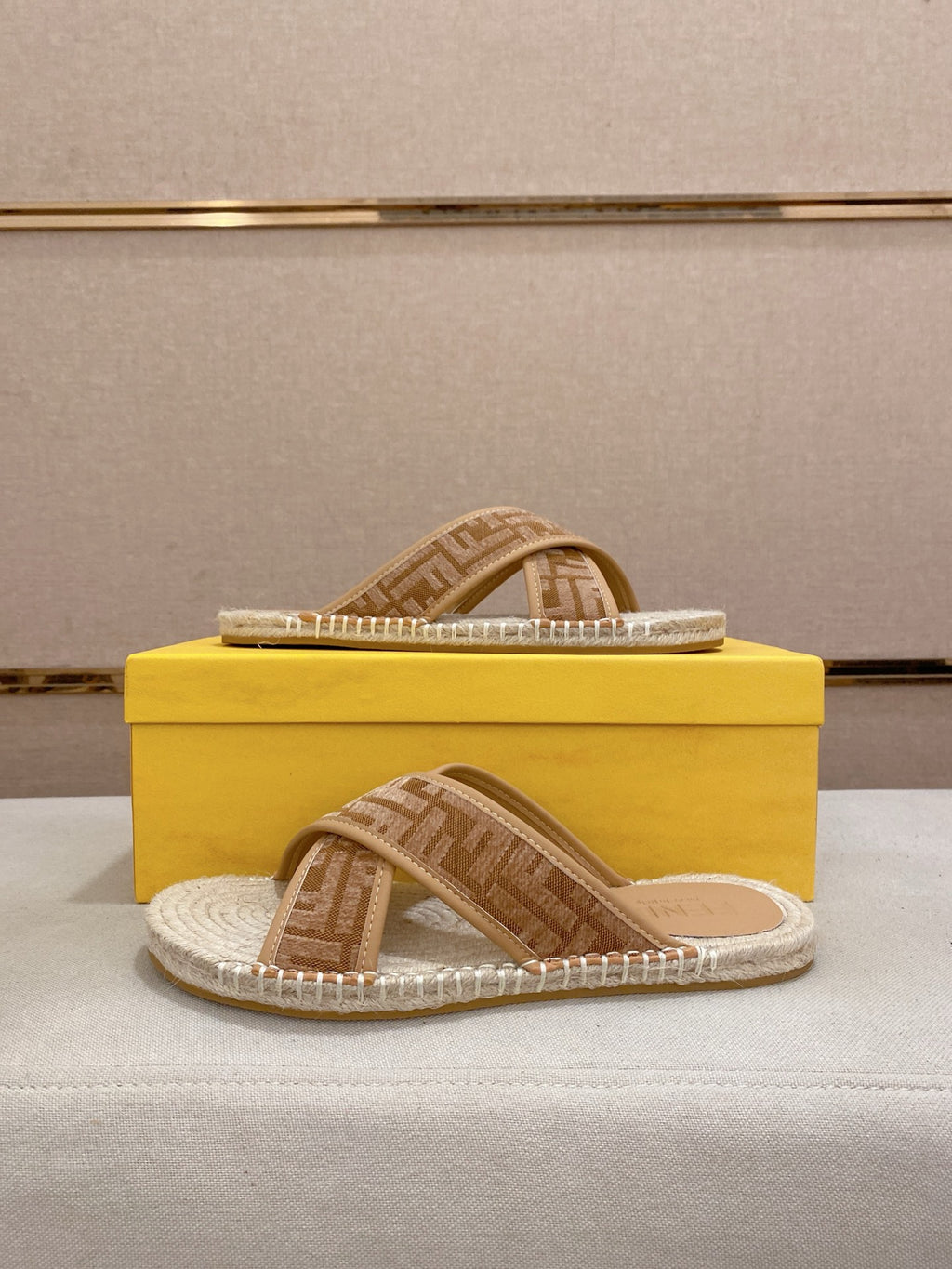 Fendi slide sandals with tan F-pattern band and braided jute-textured sole.