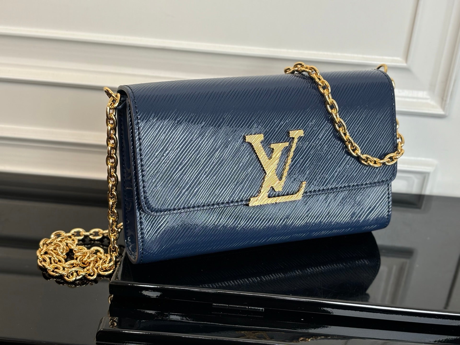 Louis Vuitton crossbody bag in navy blue with gold LV logo and chain strap