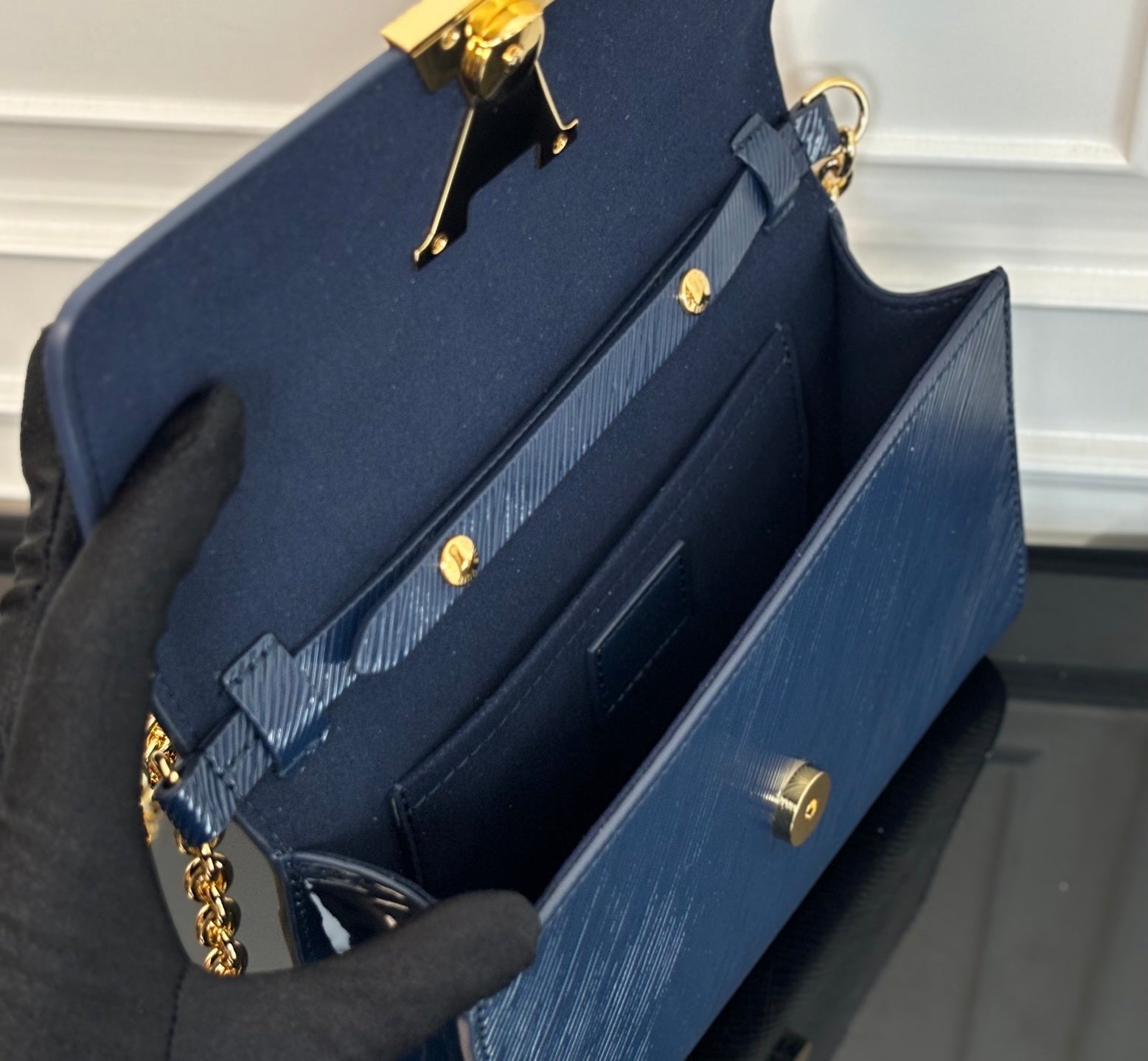 Louis Vuitton bag with open interior view and gold turn-lock hardware