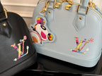 Louis Vuitton top-handle bag in light gray with LV-style graphic and multicolor charm