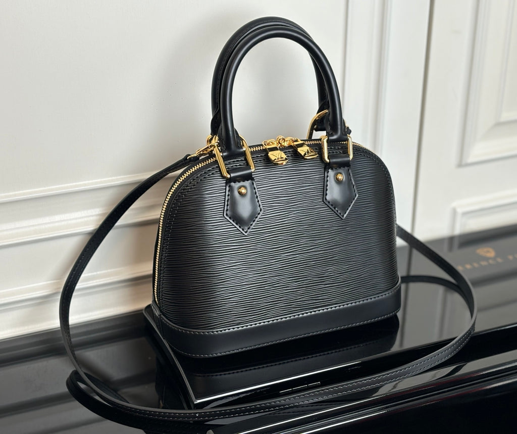 Louis Vuitton top-handle bag in dark with textured finish and gold-tone hardware