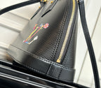 Louis Vuitton top-handle bag with textured exterior and gold-tone zipper detail