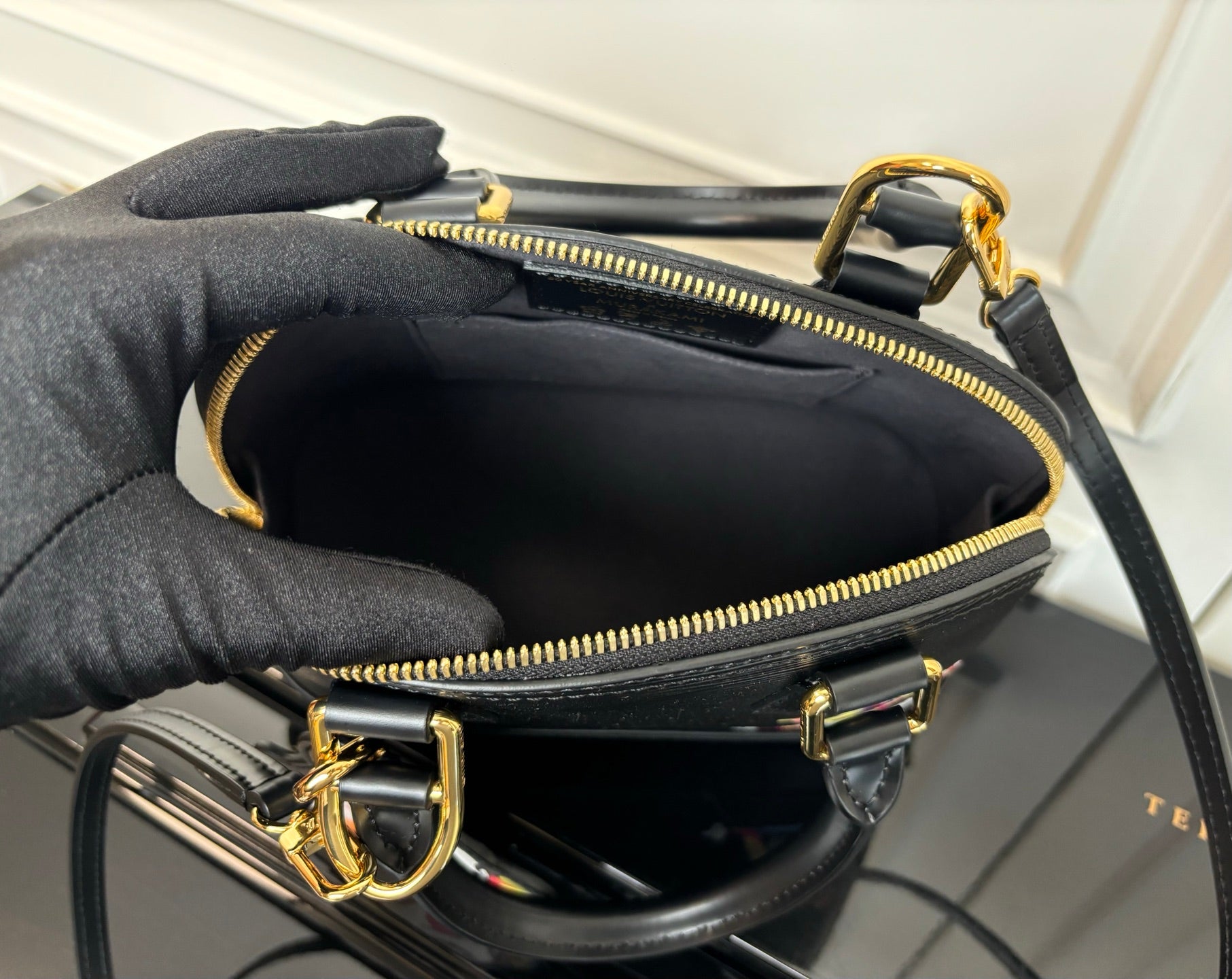 Louis Vuitton bag interior view with black lining and gold-tone zipper closure