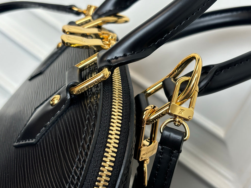 Louis Vuitton bag hardware close-up with gold-tone chain, zipper, and handle ring